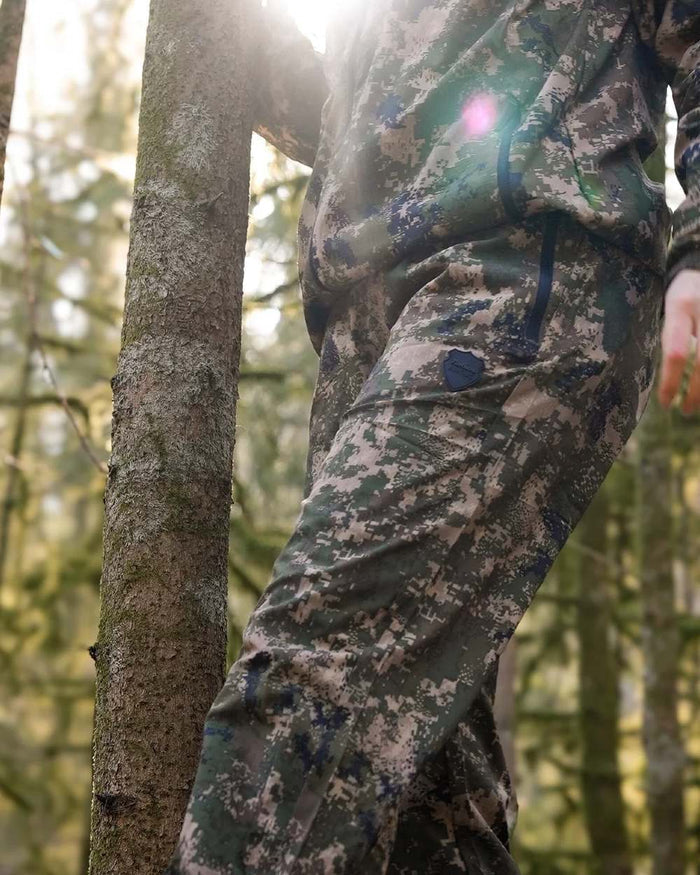 Camo coloured Northern Hunting Kjell Balk Tanatex Hunting Trousers on forest background #colour_camo