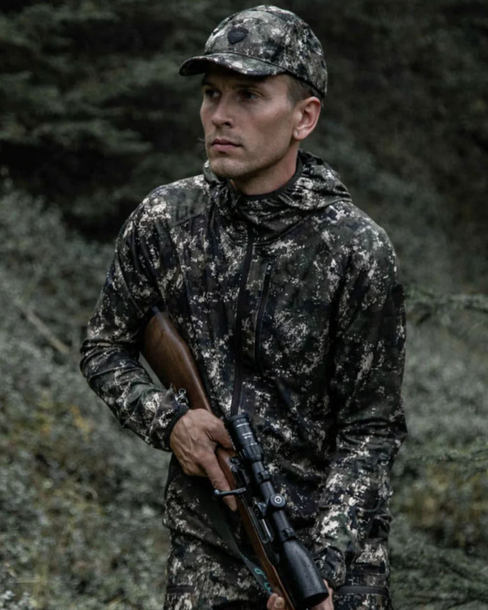 Camo coloured Northern Hunting Mens Alvar Lightweight Hunting Jacket on forest background #colour_camo