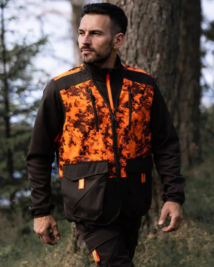 Dark Green Orange Blaze coloured Northern Hunting Mens Falkor Tark Hunting Vest on forest background #colour_dark-green-orange-blaze