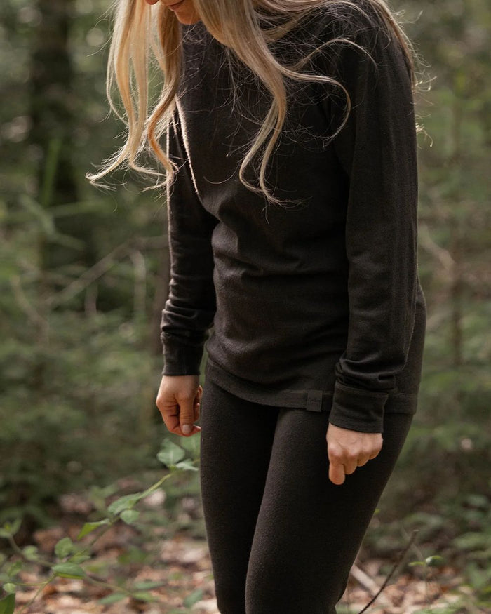 Dark Green coloured Northern Hunting Norr Fal Baselayer Pants on forest background #colour_dark-green