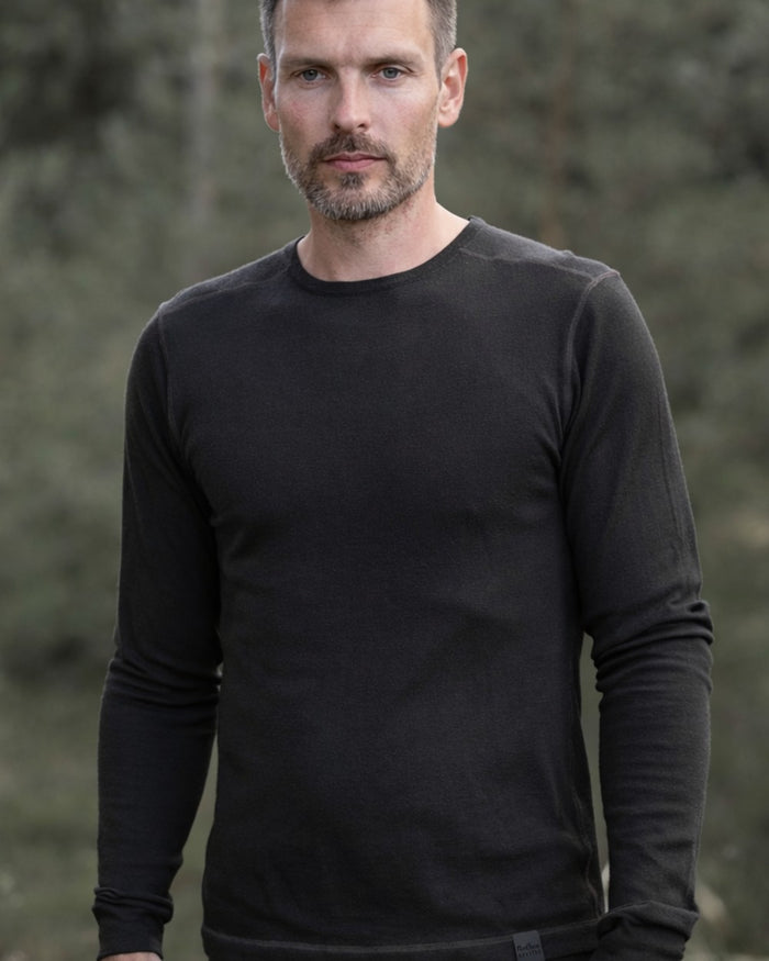 Dark Green coloured Northern Hunting Norr Vik Long Sleeve Baselayer Top on forest background #colour_dark-green