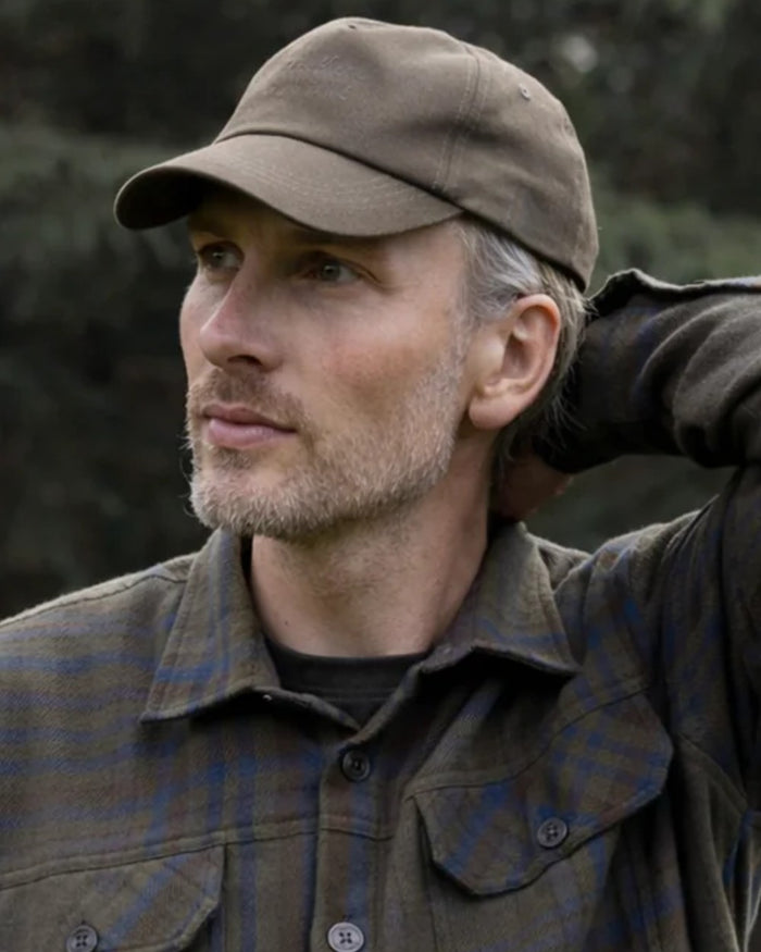 Green coloured Northern Hunting Ravn Water Repellent Cap on blurry background #colour_green