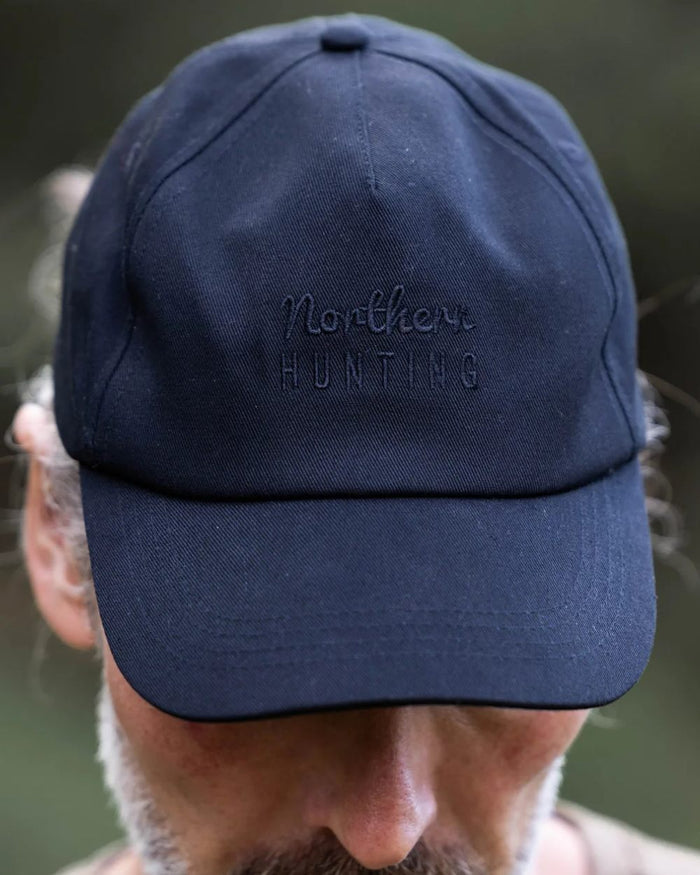 Black coloured Northern Hunting Ravn Water Repellent Cap on blurry background #colour_black