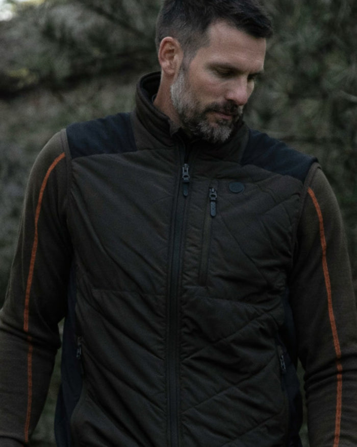 Dark Green coloured Northern Hunting Reidar Heat Vest on forest background #colour_dark-green