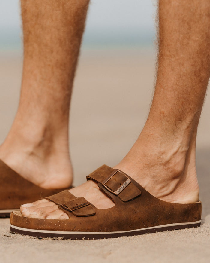 Dark Brown coloured Orca Bay Mens Saba Sandals on outdoor background #colour_dark-brown