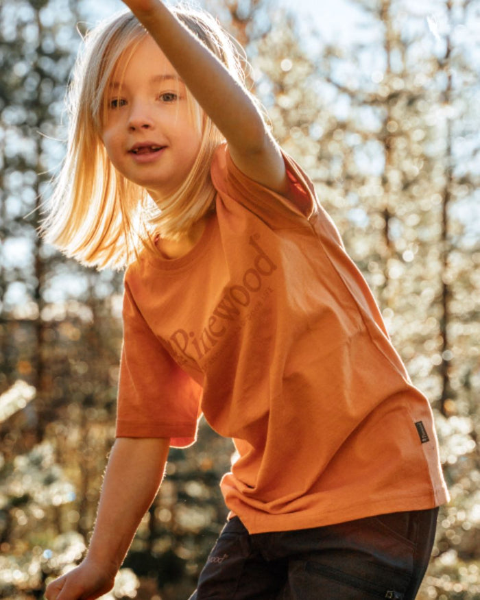 Light Terracotta coloured Pinewood Childrens Outdoor Life T-Shirt on forest background #colour_light-terracotta