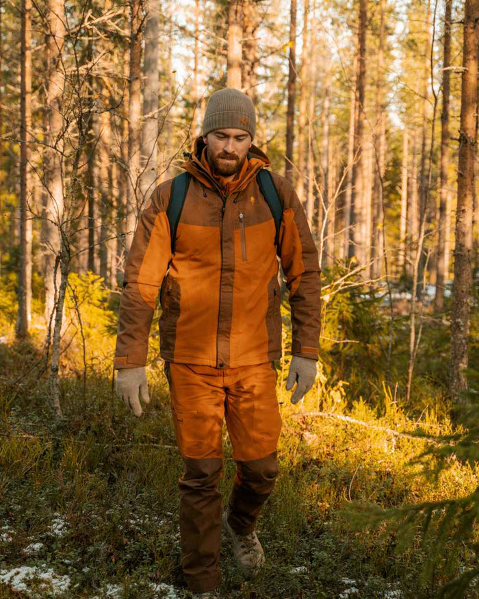 Fudge Nougat Coloured Pinewood Mens Finnveden Hybrid Extreme Jacket on forest background #colour_fudge-nougat