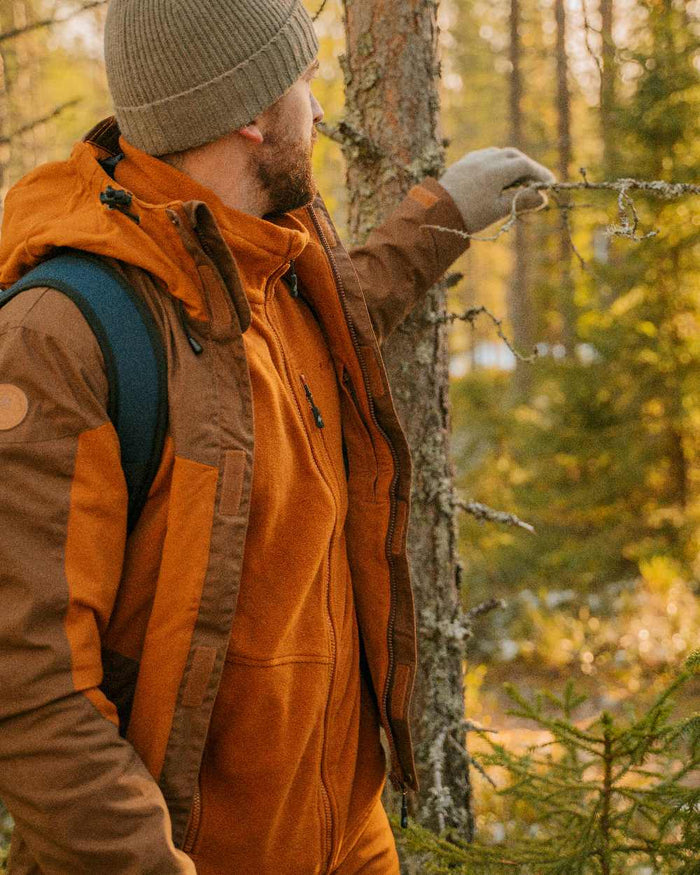Fudge Nougat Coloured Pinewood Mens Finnveden Hybrid Extreme Jacket on forest background #colour_fudge-nougat