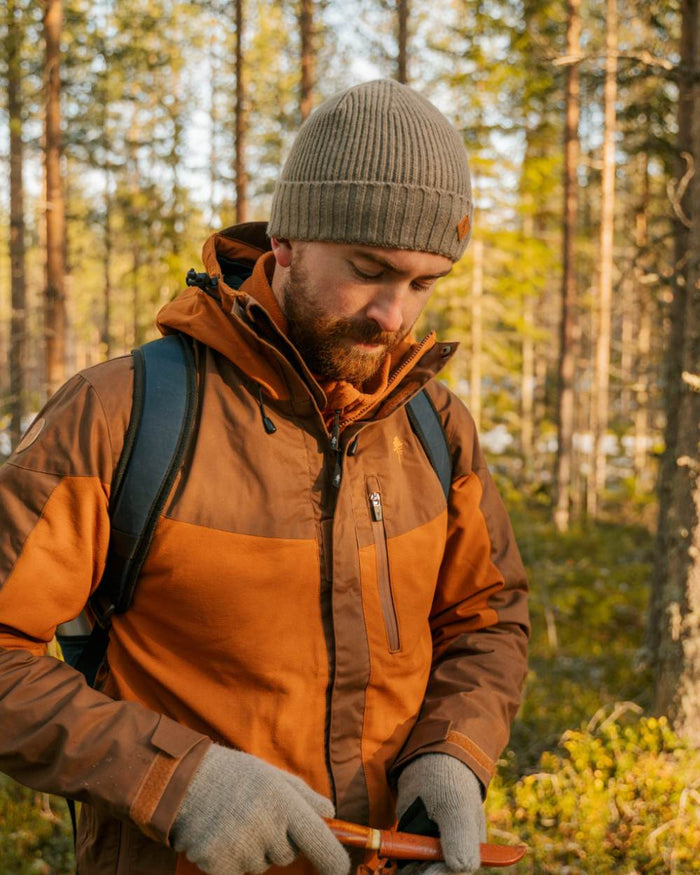 Fudge Nougat Coloured Pinewood Mens Finnveden Hybrid Extreme Jacket on forest background #colour_fudge-nougat
