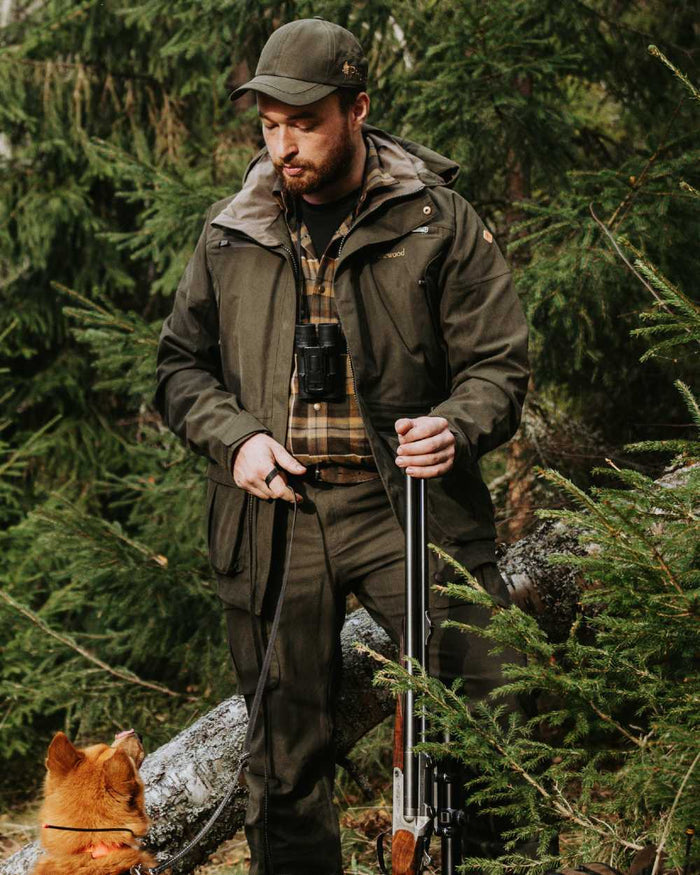Dark Moss Green coloured Pinewood Mens Furudal Expert 2L Hunting Jacket on forest background #colour_dark-moss-green