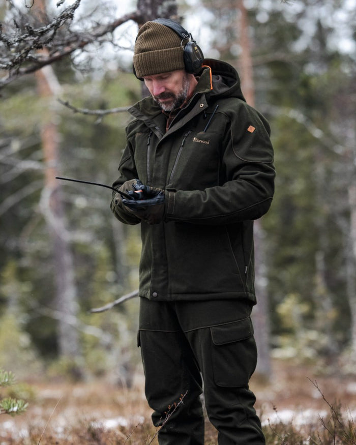 Moss Green coloured Pinewood Mens Furudal Hunters Wool Jacket on forest background #colour_moss-green