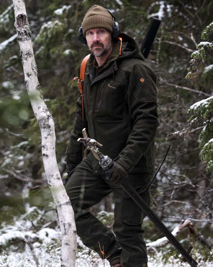 Moss Green coloured Pinewood Mens Furudal Hunters Wool Jacket on forest background #colour_moss-green