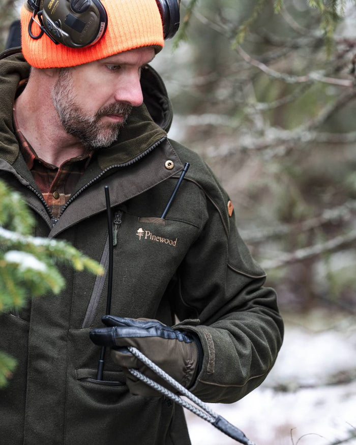 Moss Green coloured Pinewood Mens Furudal Hunters Wool Jacket on forest background #colour_moss-green