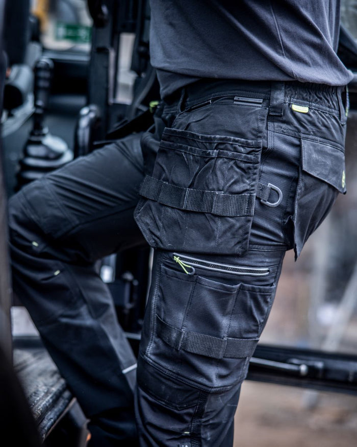 Black coloured Regatta Mens Infiltrate Softshell Stretch Trousers on blurry background #colour_black