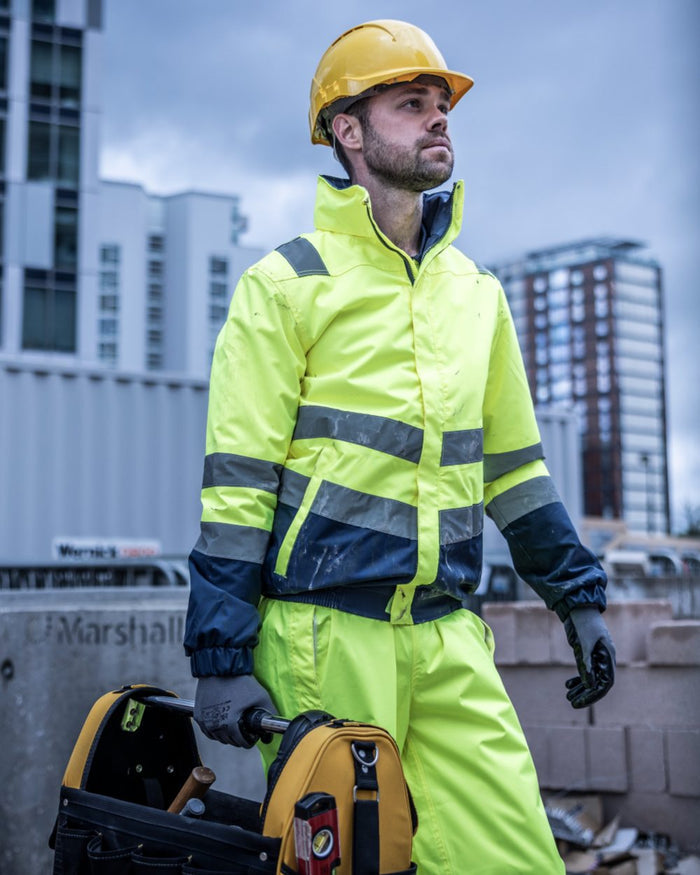 Yellow Navy coloured Regatta Professional Mens Waterproof Hi-Vis Bomber Jacket on outdoor background #colour_yellow-navy