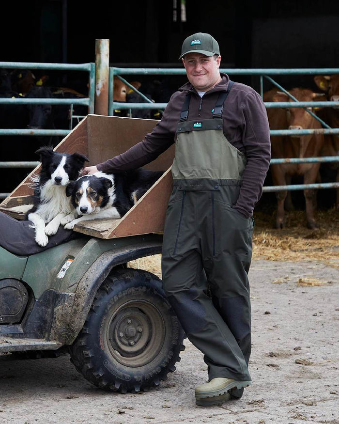 Deep Forest coloured Ridgeline Mens Agri Pro Bib & Brace on farm background #colour_deep-forest
