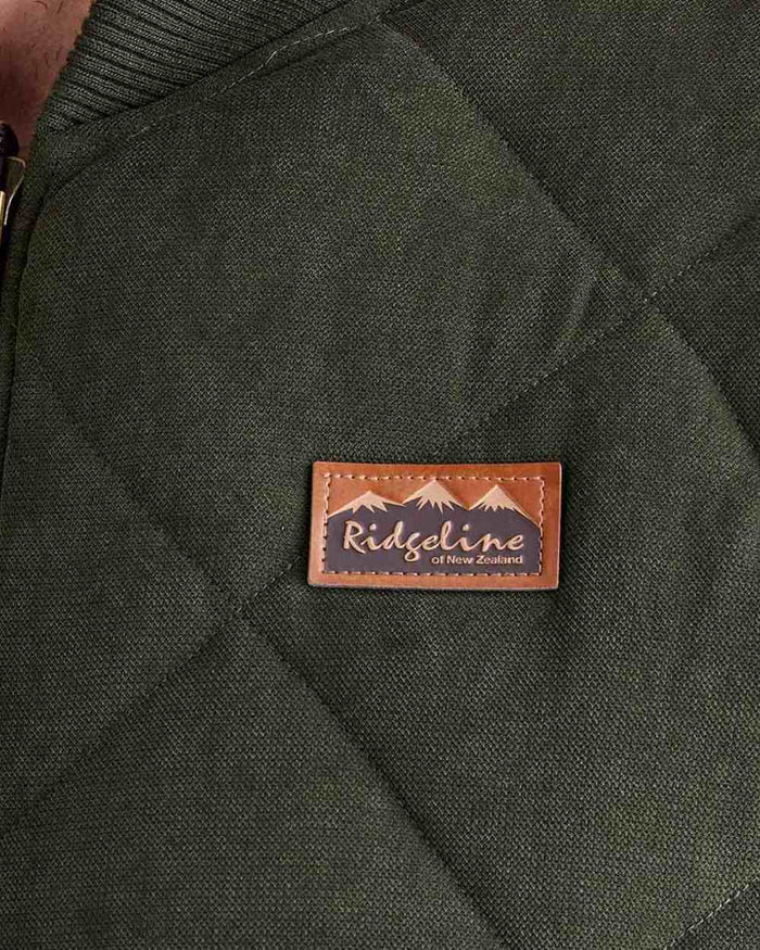 Deep Forest coloured Ridgeline Mens Wester Skeld Gilet close up logo background #colour_deep-forest