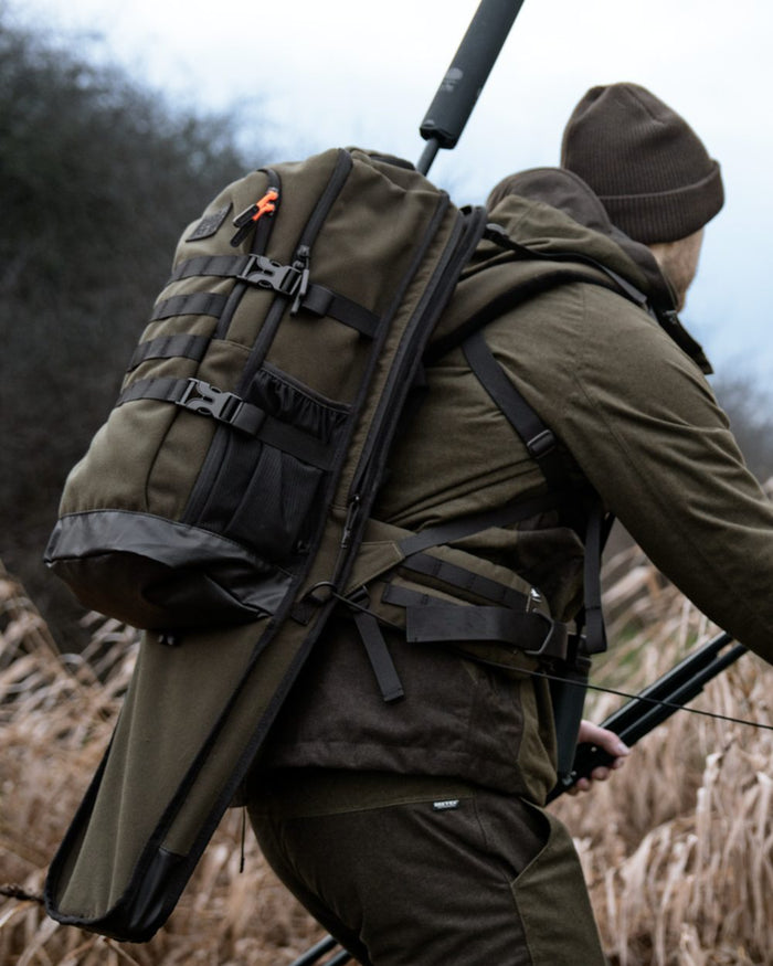 Pine Green coloured Seeland Enduro Backpack on forest background #colour_pine-green
