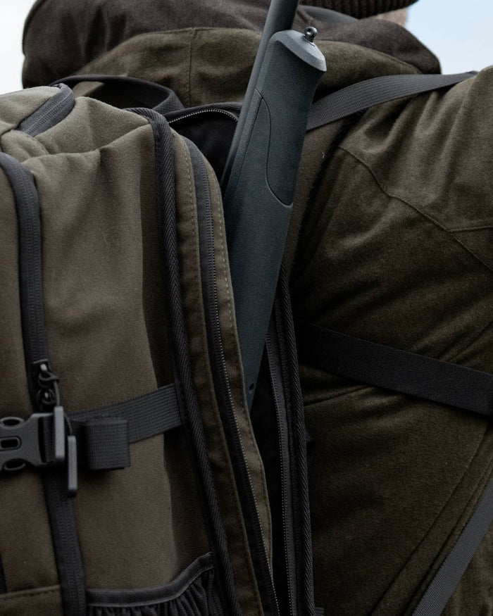 Pine Green coloured Seeland Enduro Backpack on forest background #colour_pine-green