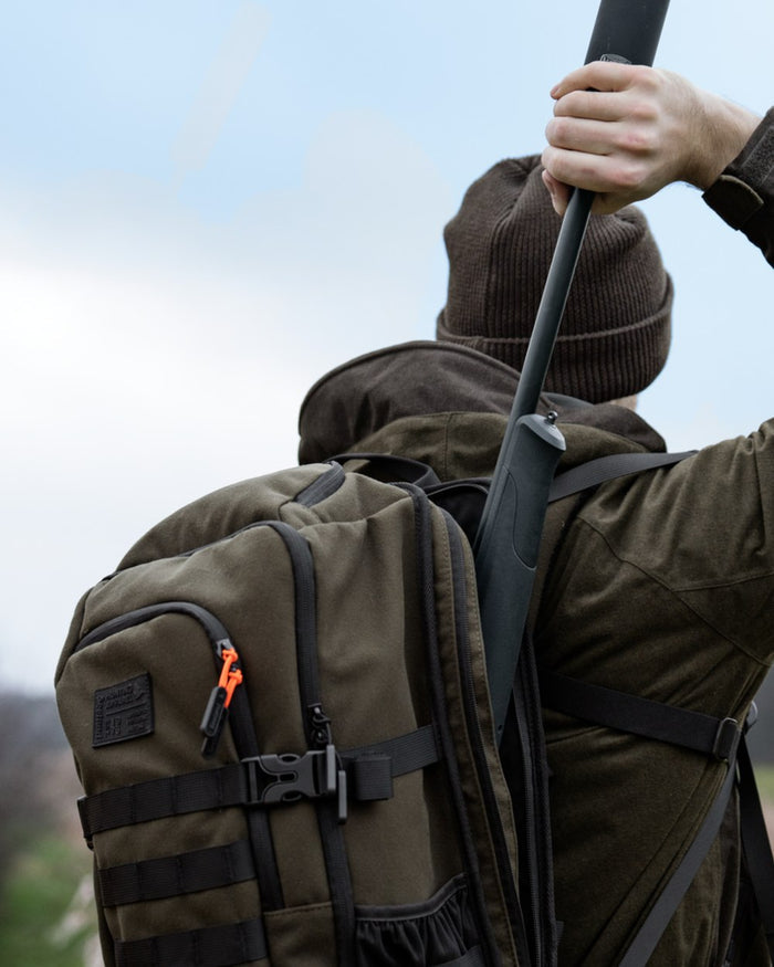 Pine Green coloured Seeland Enduro Backpack on forest background #colour_pine-green