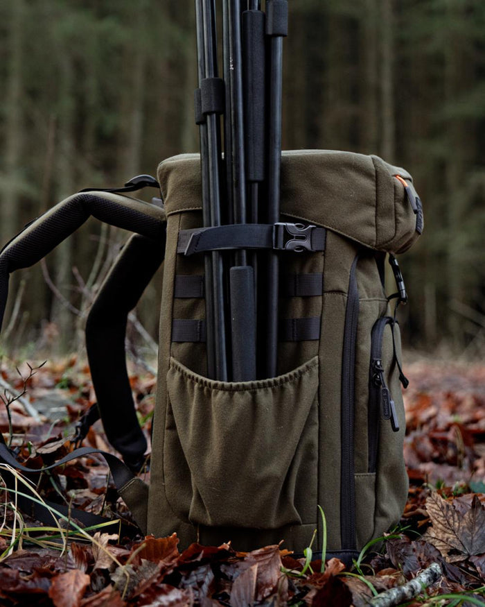 Pine Green coloured Seeland Enduro Chair Backpack on forest background #colour_pine-green