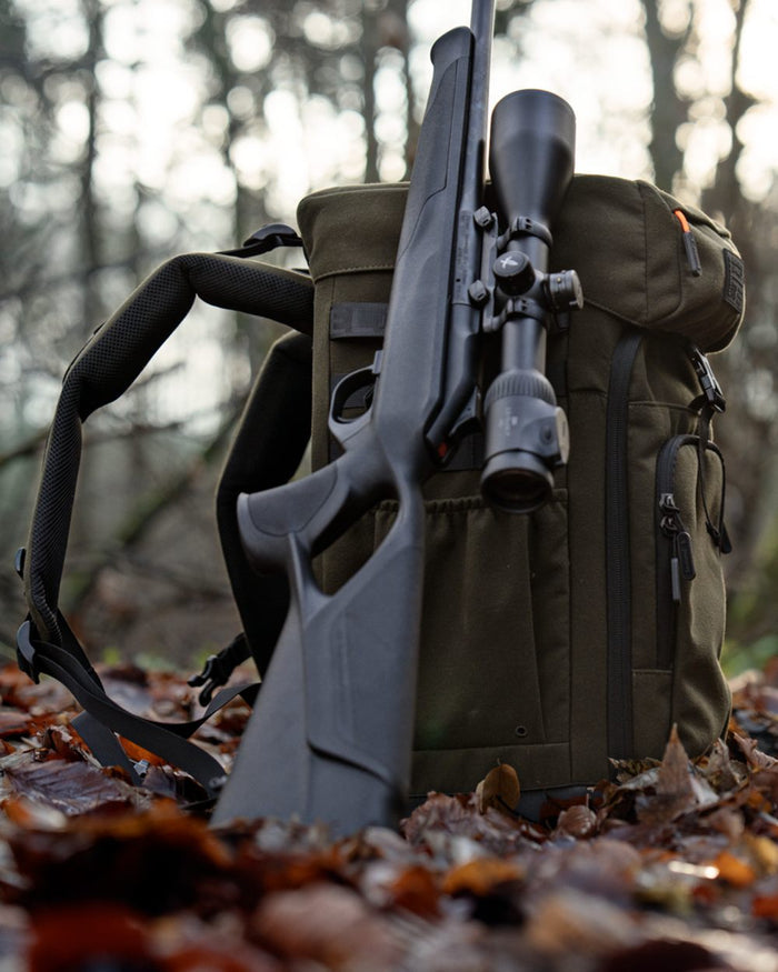 Pine Green coloured Seeland Enduro Chair Backpack on forest background #colour_pine-green