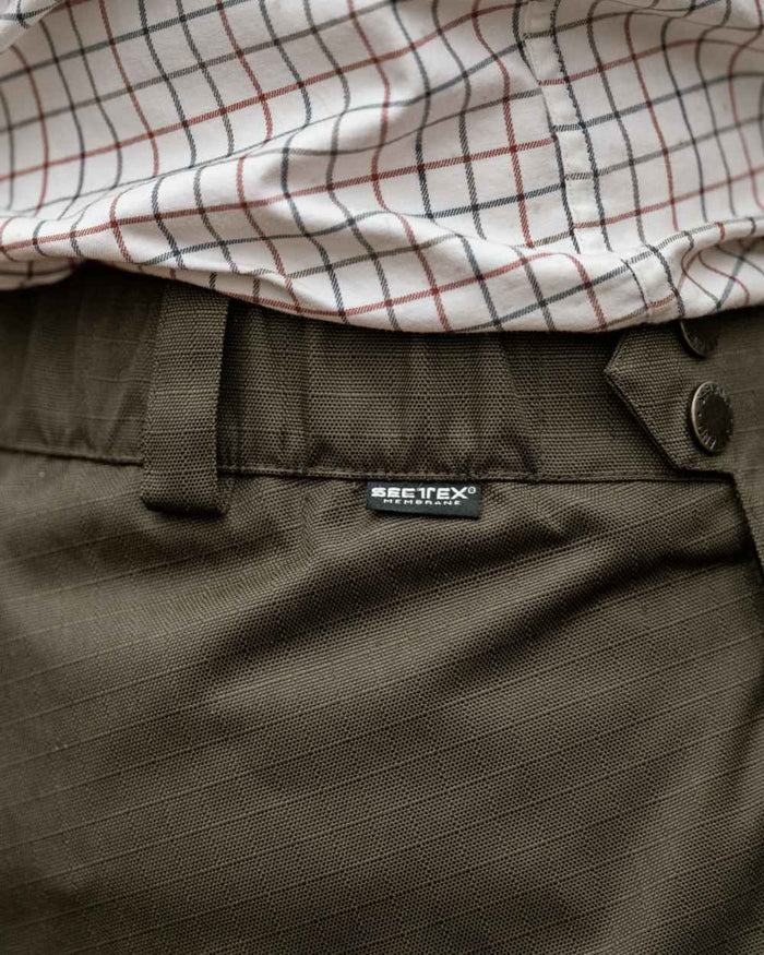 Shaded Olive coloured Seeland Mens Buckthorn Duro Overtrousers on forest background #colour_shaded-olive