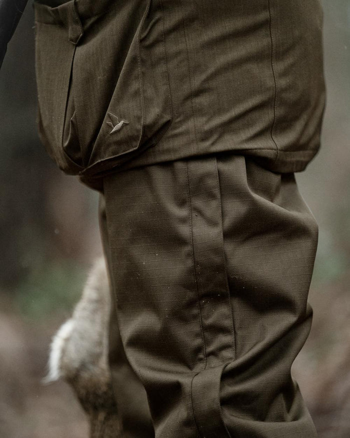 Shaded Olive coloured Seeland Mens Buckthorn Duro Overtrousers on forest background #colour_shaded-olive