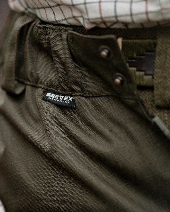 Shaded Olive coloured Seeland Mens Buckthorn Duro Overtrousers on forest background #colour_shaded-olive