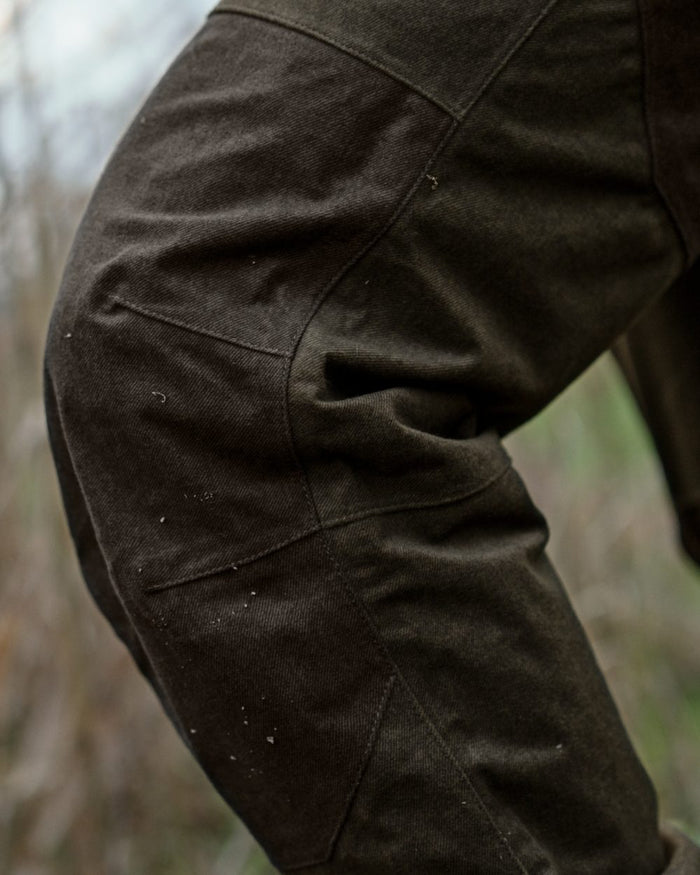 Pine Green Melange coloured Seeland Mens Quest Trousers on forest background #colour_pine-green-melange