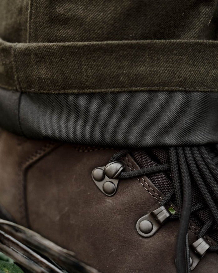 Pine Green Melange coloured Seeland Mens Quest Trousers on forest background #colour_pine-green-melange