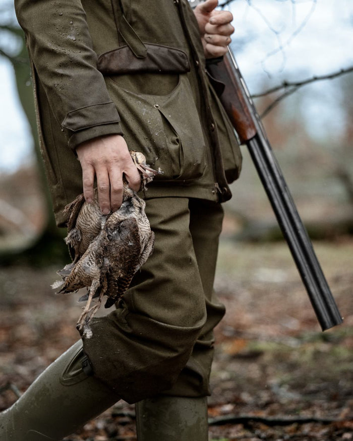 Shaded Olive coloured Seeland Mens Woodcock Royale Breeks on forest background #colour_shaded-olive