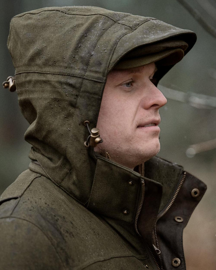 Shaded Olive coloured Seeland Mens Woodcock Royale Jacket on forest background #colour_shaded-olive