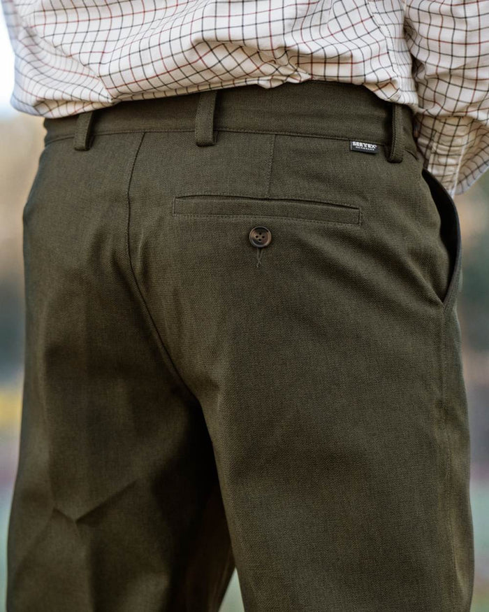 Shaded Olive coloured Seeland Mens Woodcock Royale Trousers on forest background #colour_shaded-olive