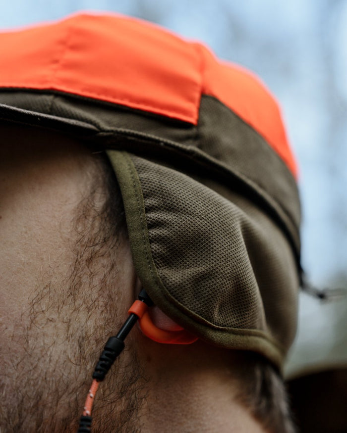 Grizzly Brown coloured Seeland Ultimo Cap on forest background #colour_grizzly-brown