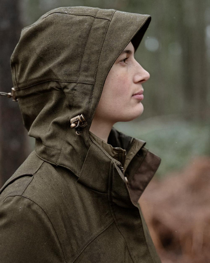 Shaded Olive coloured Seeland Womens Woodcock Royale Eve Jacket on forest background #colour_shaded-olive