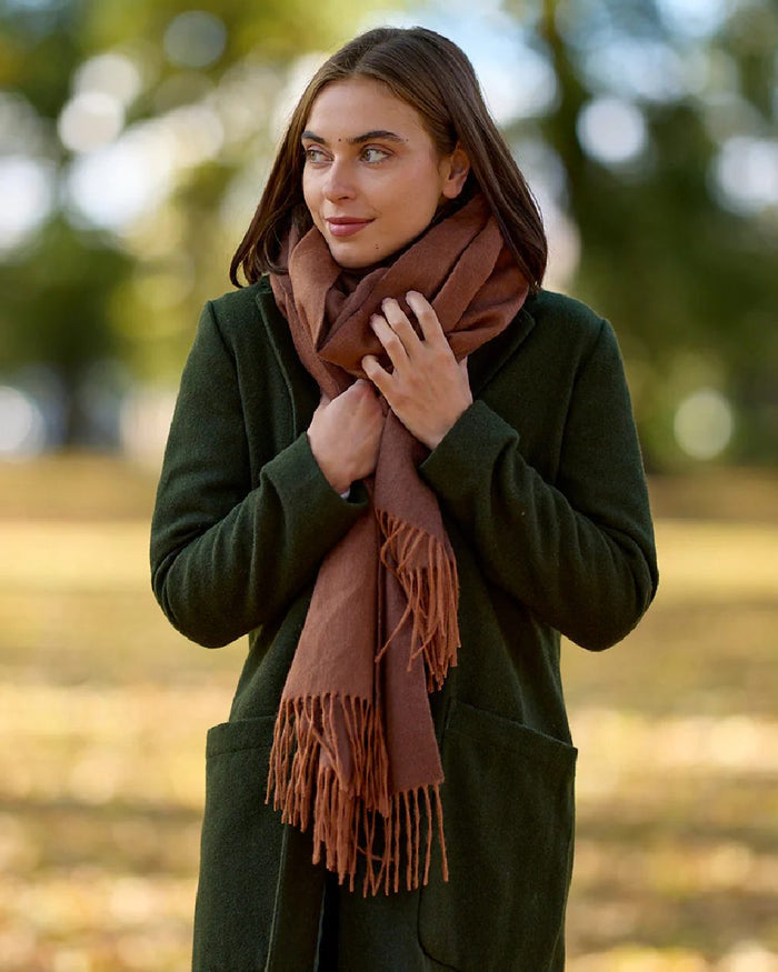 Rusty Coloured Swanndri Womens Wide Scarf on outdoor background #colour_rusty