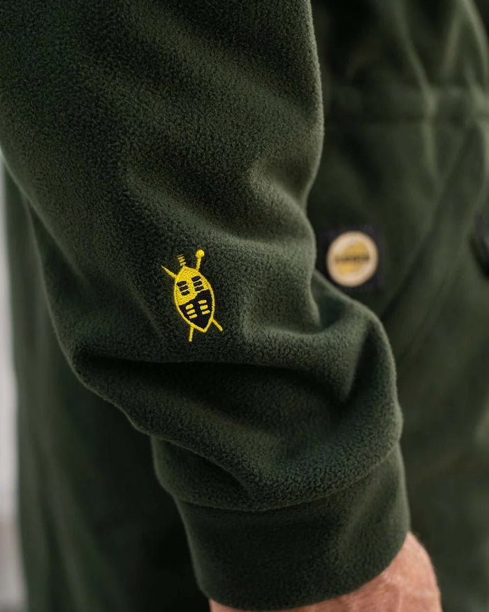 Olive coloured Swazi Mens Windriver Jacket on floor background #colour_olive