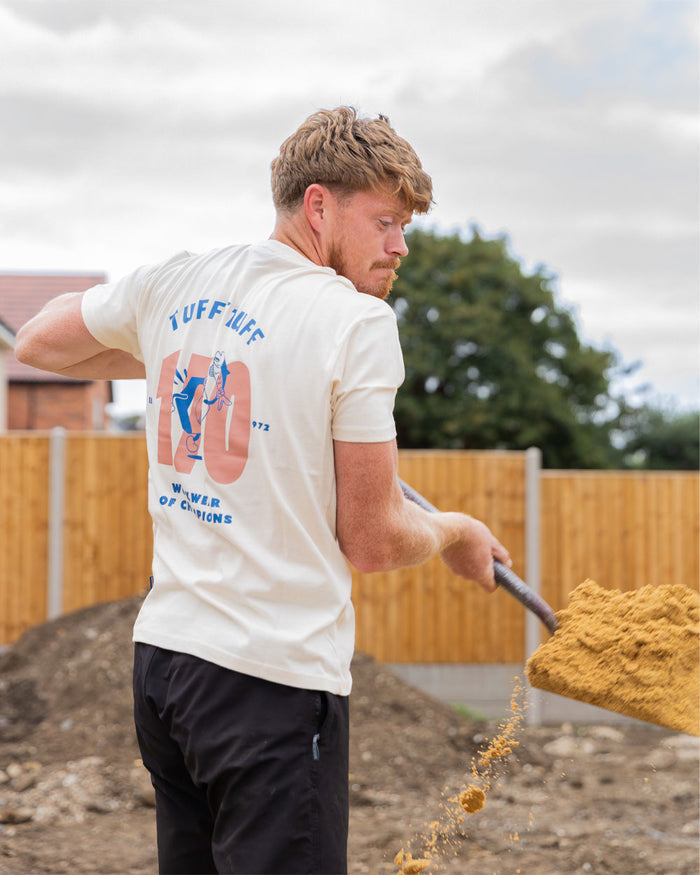 Male model wearing White coloured TuffStuff Icon T-Shirt shovelling sand #colour_white