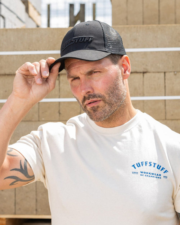 Black coloured TuffStuff Trucker Cap on construction background #colour_black