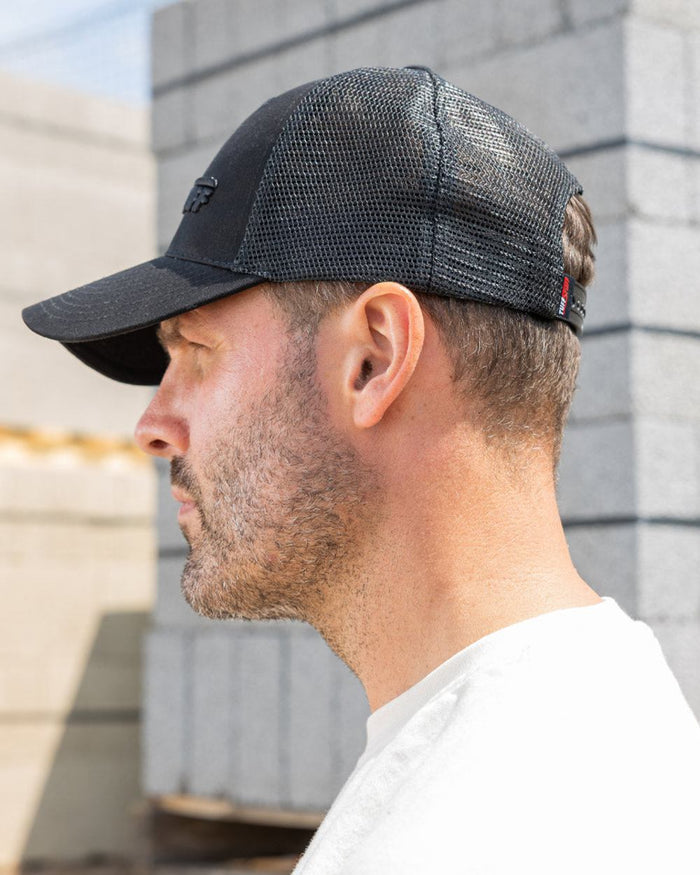 Black coloured TuffStuff Trucker Cap on construction background #colour_black