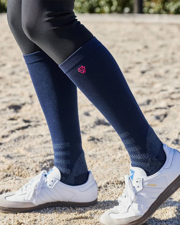 Navy Bright Pink coloured Weatherbeeta Compression Knee Length Riding Socks on ground background #colour_navy-bright-pink