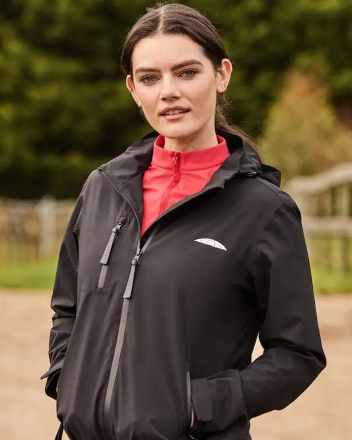 Black Coloured WeatherBeeta Jackson Waterproof Jacket On A Field Background #colour_black