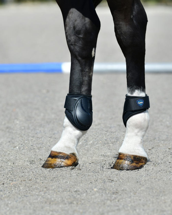 Black Coloured WeatherBeeta Tough-Tec Essential Fetlock Boots on horse background #colour_black