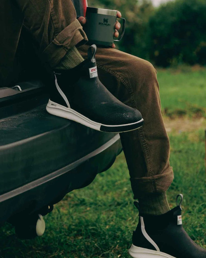 Black Coloured Xtratuf Mens 6" Ankle Deck Sport Boots on outdoor background #colour_black